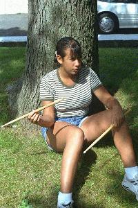 Dana twirling a drumstick in front of her house.